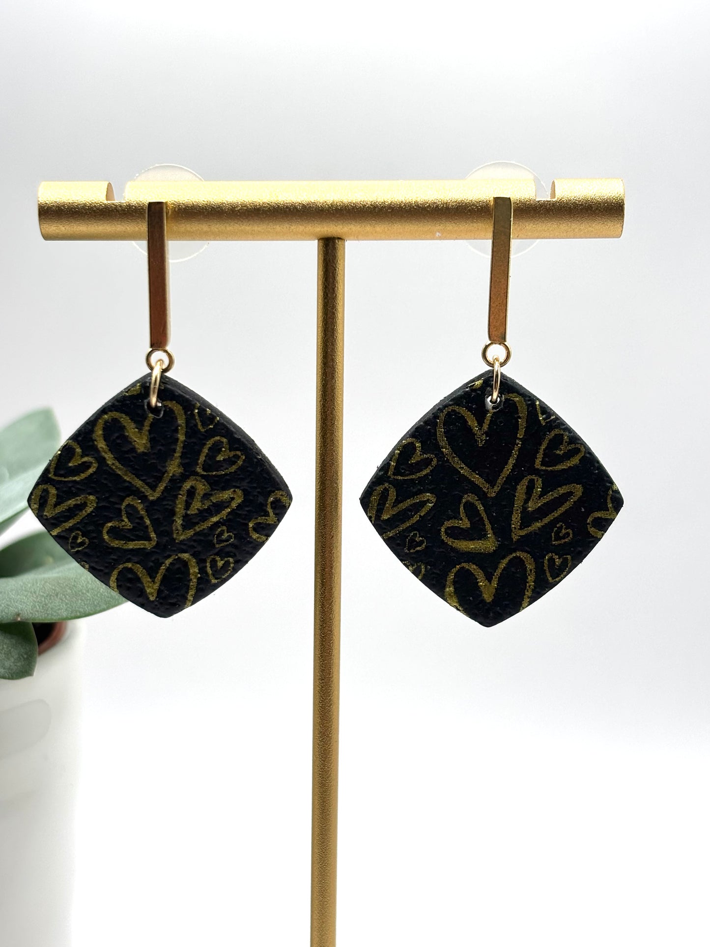 The one with the hearts rounded square black/gold