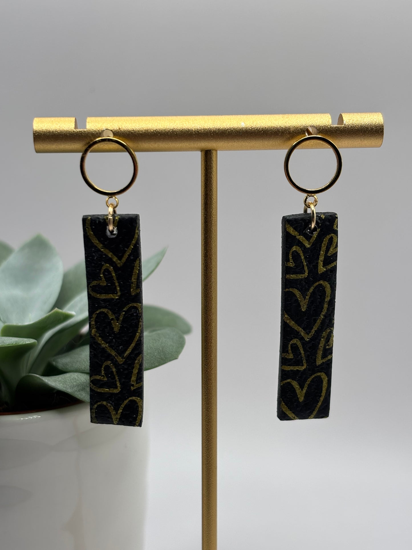 The one with the hearts rectangle black/gold